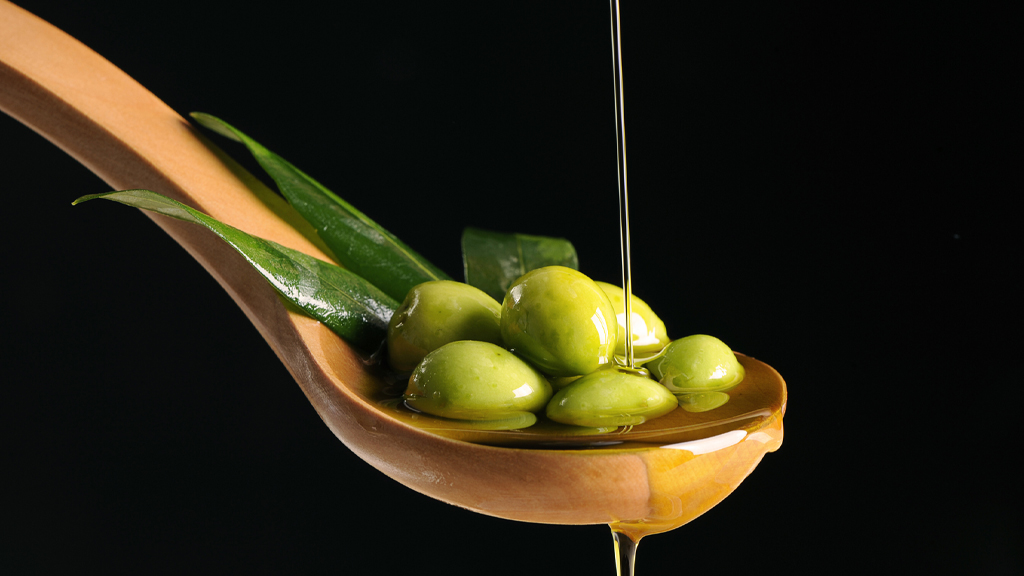 cucchiaio con olive e olio di oliva