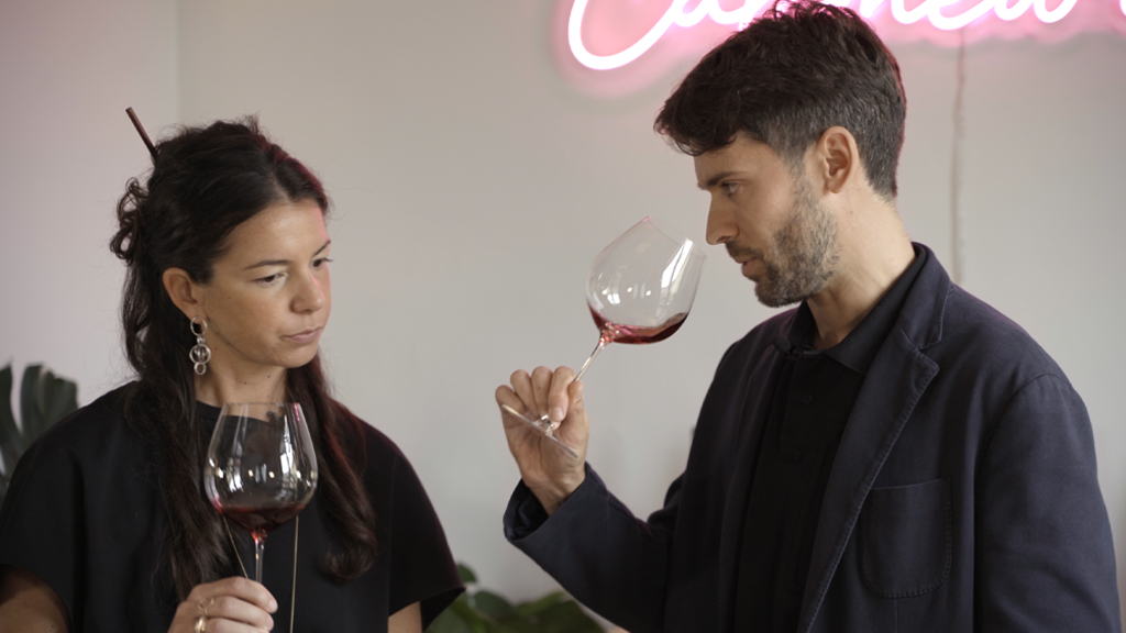 Primo piano di Matteo Riccomagno e Chiara Buzzi nella sede di Callmewine, degustando un vino rosso