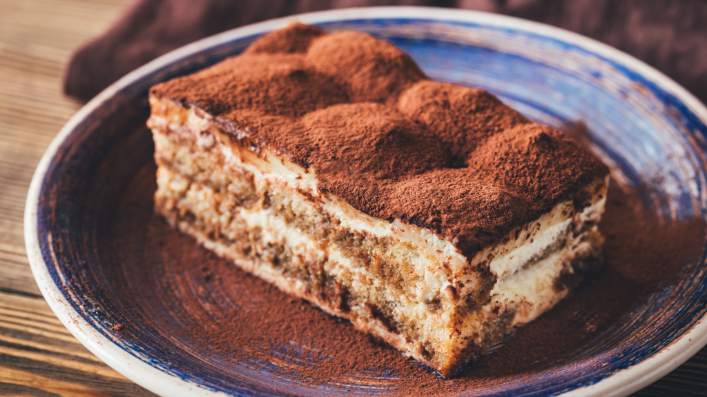 Tiramisù su piatto blu su tavolo di legno