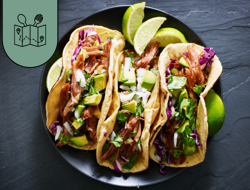 copertina con piatto con tre tacos di carne con lime su sfondo nero