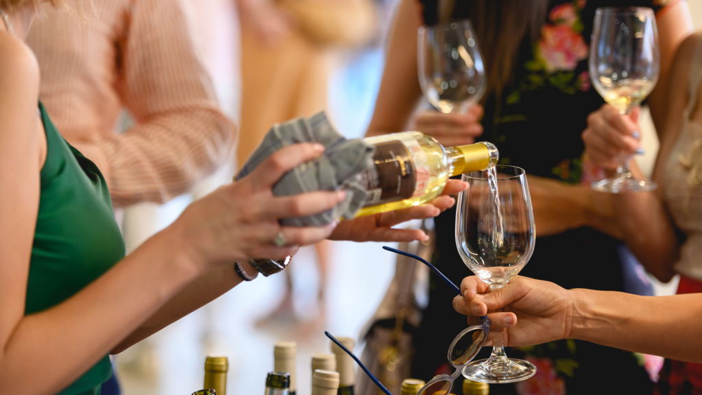foto di una ragazza che sta versando una bottiglia di vino in un calice