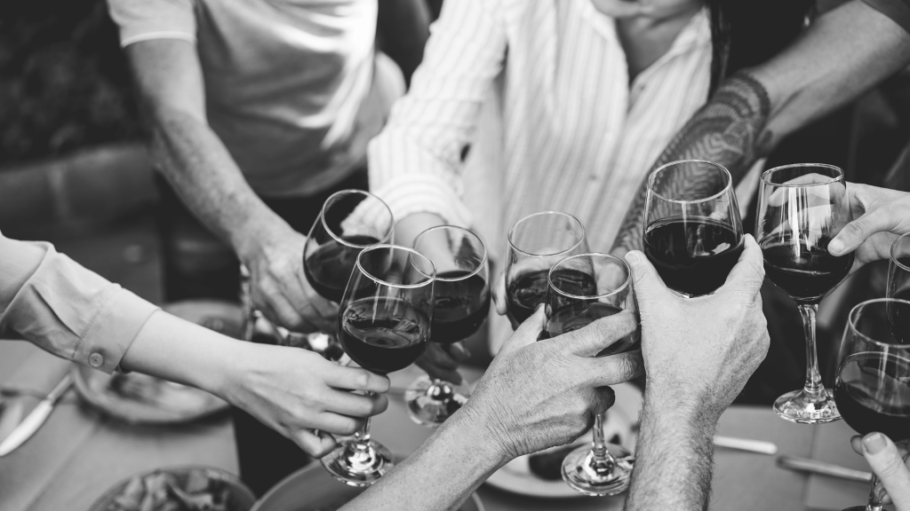 foto in bianco e nero di tante persone che stanno facendo un brindisi